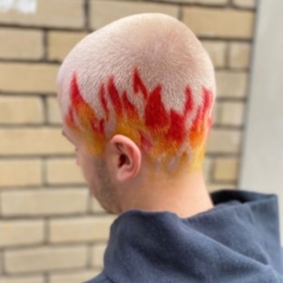Reflections Hair Group Competition work showing a close shaved head with red and orange flames growing up from the base